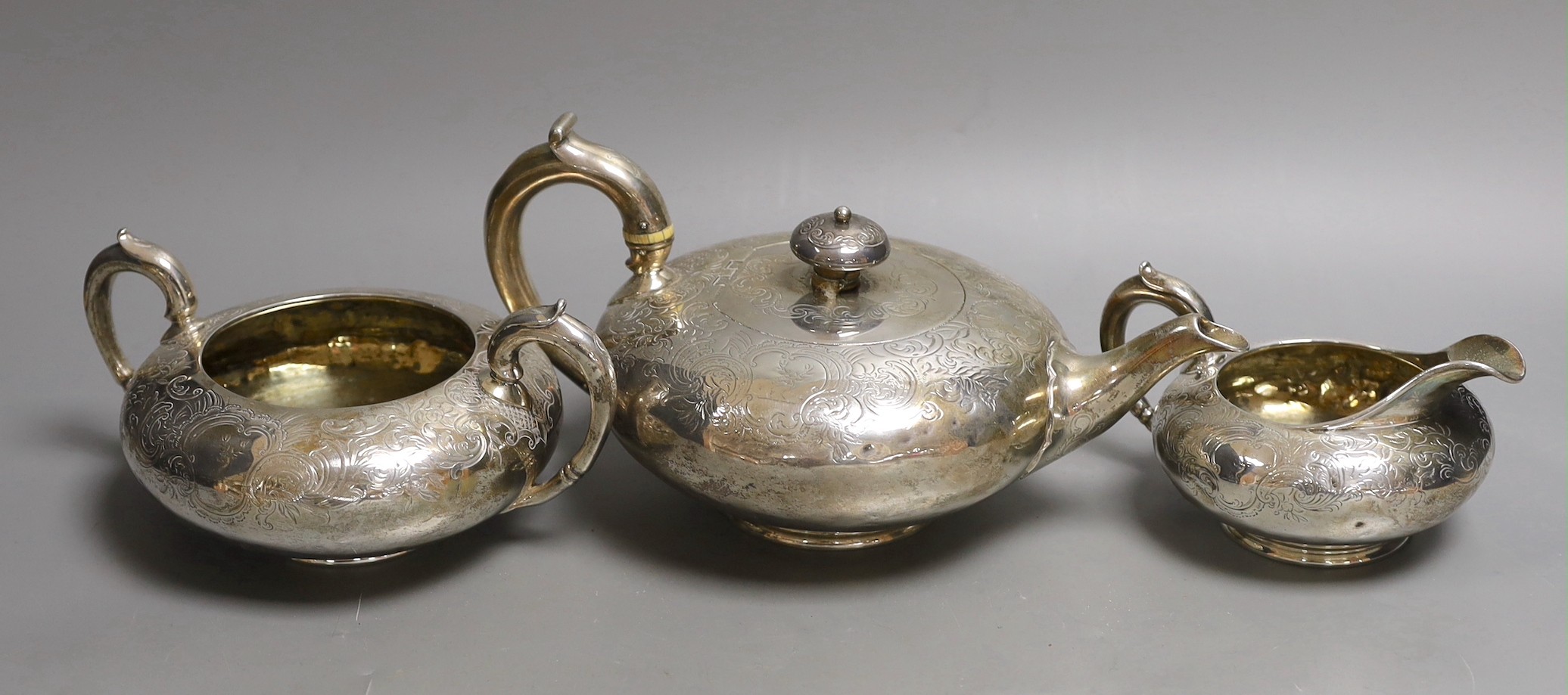 An early Victorian engraved silver three piece tea set, W.E, London, 1839, gross 38oz.